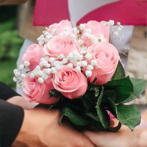 pink-and-white-bouquet-in-the-hands-of-the-bride-and-groom-at-the-ceremony